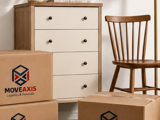 Chest of drawers, a chair and packed boxes ready to be moved from a living room